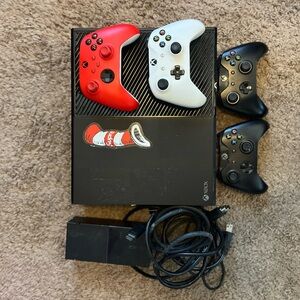 Microsoft Console with Red, White, and Black Controllers